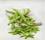 Green beans, some chopped, on a chopping board — Stock Photo