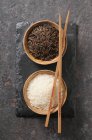 Білий і чорний рис в невеликих мисках (вид зверху ) — стокове фото