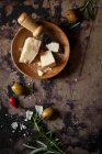 Queijo parmesão em uma tigela de madeira com uma pequena faca de queijo — Fotografia de Stock