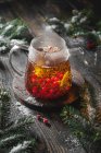 Preparar té negro con bayas de viburnum y limón con ramas de abeto y nieve - foto de stock