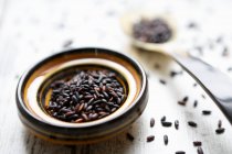 Black rice in a bowl and on a spoon — Stock Photo