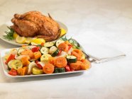 Жареная курица и овощные тарелки — стоковое фото