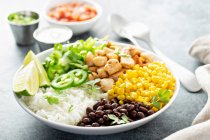 Roasted chicken thighs with rice, beans, corn, lime and herbs — Stock Photo