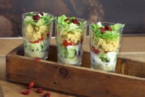 Couscous salad with tomatoes, iceberg lettuce and cranberries in glasses — Stock Photo