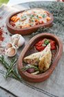 Stuffed squid and a seafood bake in serving bowls — Stock Photo
