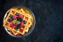 Belgian waffles with fresh berries on a plate (seen from above) — Stock Photo