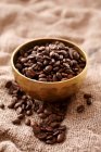 Coffee beans in a metal bowl on a jute cloth — Stock Photo