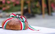 Ein Laib Brot, umwickelt mit roter, weißer und grüner Schleife — Stockfoto