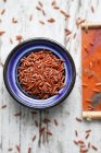 Red rice in a bowl on a colourful background (seen from above) — Stock Photo