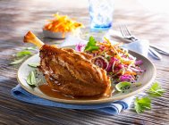Pork knuckle with coleslaw served on table — Stock Photo