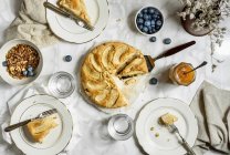 Mesa con Gluten libre vegano pastel de manzana rodajas Granola bayas - foto de stock