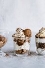 Chocolate and vanilla desserts in glass jars — Stock Photo