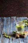 Houblon thé dans une tasse en verre sur une planche à découper — Photo de stock