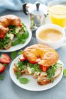 Sandwich de desayuno en un croissant con pavo, rúcula, fresas y brie - foto de stock