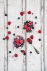 Greek yoghurt with fruit jelly and fresh raspberries and blueberries on wooden surface — Stock Photo