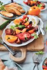 Caprese salad platter with tomatoes, mozzarella, basil, croutons and olives — Stock Photo