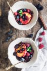 Грильовані ягоди та персики подаються в мисках — стокове фото