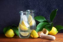 Homemade lemonade in glass jugs with fresh lemons and leaves — Stock Photo