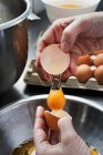 Um ovo sendo rachado em uma tigela — Fotografia de Stock