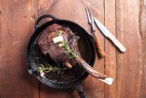 Bife de tomahawk em panela de ferro fundido, temperado com manteiga e alecrim — Fotografia de Stock