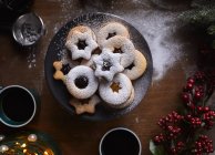 Freshly baked Linzer cookies being dusted with sugar — Stock Photo