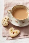 Biscotti con pistacchi e petali di rosa secchi, serviti con una tazza di caffè — Foto stock
