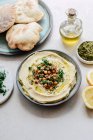 Hummus sprinkled with chickpeas and parsley served with pita bread — Stock Photo