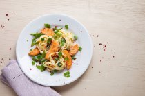 Tagliatelle with salmon, sugar snap peas and spring onions — Stock Photo