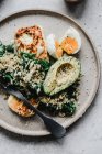Hirse mit Avocado-Grünkohl-Ei und gegrilltem Halloumi mit Tahini-Sauce — Stockfoto