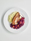 Нарізати свинину з тушкованою червоною капустою та картопляним пюре — стокове фото