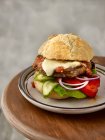 A portobello burger with grilled peppers, cucumber slices, red onion rings, mozzarella, and tomato and pepper salsa — Stock Photo