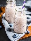 Vegan blueberry smoothie in small bottles — Stock Photo