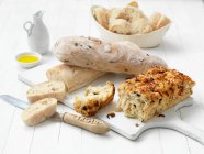 Various types of bread on a chopping board — Stock Photo