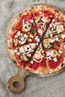 Una pizza con mariscos y tomates - foto de stock