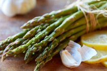 Green asparagus, garlic and lemons — Stock Photo