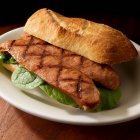 Сэндвич с колбасой на гриле на ручном хлебе — стоковое фото