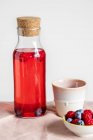Summer drink with berries in a glass bottle — Stock Photo