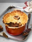 Bone marrow pie in an oven dish, with a piece missing (England) — Stock Photo