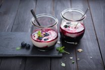Мигдальний йогурт з чорничним компотом у склянці — стокове фото
