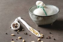 Italian fresh burrata cheese in a ceramic mousse with spices and pine nuts — стокове фото