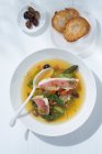 Red mullet with green asparagus, saffron, small Nice olives, and toasted bread (Southern France) — Stock Photo