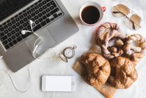 Frühstück im Büro mit Kaffee und süßen Brezeln — Stockfoto