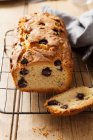 Un pastel de pan de arándano en rodajas en un estante de enfriamiento de alambre - foto de stock