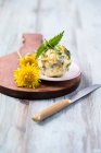 Uma bola de manteiga de ervas com dentes-de-leão, urtigas e cebolinha — Fotografia de Stock