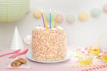 Um bolo de aniversário coberto de polvilhas com cinco velas — Fotografia de Stock