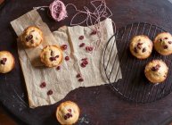 Muffins de cranberry recém-assados resfriando em cremalheira e pergaminho — Fotografia de Stock