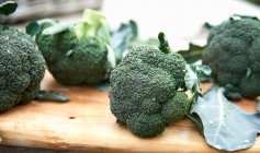 Fresh green broccoli on wooden background — Stock Photo