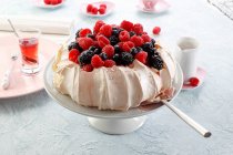 Pavlova with fresh fruit and rose syrup — Stock Photo