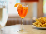 Aperol spritz з апельсиновим шматочком за столом ресторану — стокове фото