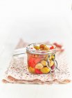 Lacto fermented green olives and red peppers in a mason jar — Stock Photo